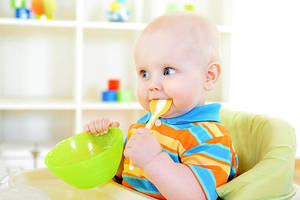 young-toddler-with-plastic-green-spoon-in-his-mouth-picture-id175393954
